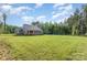 Expansive backyard featuring a lush lawn and wooded area, offering privacy and space for outdoor activities at 11226 Dappled Light Trl, Charlotte, NC 28227