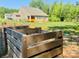 Wooden compost bin in the backyard with home partially visible in the background at 11226 Dappled Light Trl, Charlotte, NC 28227