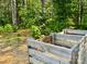 Wooden compost bin in backyard surrounded by trees, bushes, and greenery at 11226 Dappled Light Trl, Charlotte, NC 28227