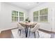Cozy dining area features modern table, comfortable seating, and natural light from two windows at 11226 Dappled Light Trl, Charlotte, NC 28227