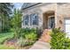 Charming brick entrance with manicured garden, black iron railing, and inviting arched entryway at 11226 Dappled Light Trl, Charlotte, NC 28227