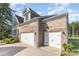 Spacious two-car garage with white doors complementing the brick exterior and well-maintained surroundings at 11226 Dappled Light Trl, Charlotte, NC 28227