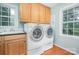 Sunlit laundry room with wooden cabinets, granite countertops and hardwood floors at 114 Larkfield Dr, Waxhaw, NC 28173