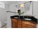 Updated bathroom featuring double sinks, dark granite countertops, wood cabinets, and modern fixtures at 117 N Central Ave, Belmont, NC 28012