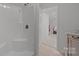 Bright bathroom featuring a shower with a white shower surround and a vanity on the side with an open doorway at 117 N Central Ave, Belmont, NC 28012