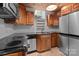 Well-equipped kitchen with stainless steel appliances, granite countertops, wood cabinets and tile flooring at 117 N Central Ave, Belmont, NC 28012