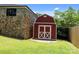 Charming red barn-style outbuilding with white trim, set against a lush green lawn at 117 N Central Ave, Belmont, NC 28012