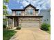 Two-story home featuring a stone facade, a two-car garage, a manicured lawn, and a welcoming covered front porch at 1314 San Gabriel Ave, Charlotte, NC 28214