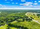 Aerial view showcasing the property and the surrounding wooded area, with distant view of community shopping centers at 13715 Mayes Rd, Huntersville, NC 28078