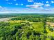 Aerial view highlighting the property and the surrounding landscape, with distant views of commercial areas and the horizon at 13715 Mayes Rd, Huntersville, NC 28078