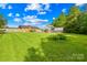 Lush backyard with a large, manicured lawn and various storage structures, ideal for outdoor enjoyment and organization at 13715 Mayes Rd, Huntersville, NC 28078