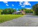 Ranch home with a long gravel driveway, screened porch, and large grassy front yard at 13715 Mayes Rd, Huntersville, NC 28078