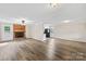 Open-concept living room featuring hardwood floors and a brick fireplace at 13715 Mayes Rd, Huntersville, NC 28078