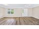 Sunny living room featuring a large window and light-colored hardwood flooring at 13715 Mayes Rd, Huntersville, NC 28078