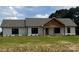 Charming home with white siding, dark framed windows and a wooden entry sitting on a spacious green lawn at 1389 Hartsoe Rd, Lincolnton, NC 28092