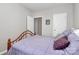 Bright bedroom featuring a wooden bed frame with mauve bedding and a door to the ensuite at 14451 San Paolo Ln, Charlotte, NC 28277