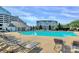 Community pool area with bright blue water and seating areas and community buildings at 14451 San Paolo Ln, Charlotte, NC 28277
