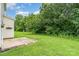A well-maintained backyard featuring a patio and lush green grass extending to mature trees at 14911 Taggert Trail Dr, Charlotte, NC 28273