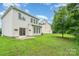 Backyard features lush green lawn, mature trees, and the home's rear facade, including a patio area at 14911 Taggert Trail Dr, Charlotte, NC 28273