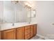 Bathroom with double sinks, light wood cabinets, a large mirror, and gray vinyl flooring at 14911 Taggert Trail Dr, Charlotte, NC 28273