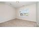 This is a photo of a neutrally painted bedroom with carpet, a window that lets in light, and neutral walls at 14911 Taggert Trail Dr, Charlotte, NC 28273