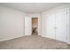 This is a photo of a neutrally painted bedroom with carpet, closet, an open doorway leading to stairs, and neutral walls at 14911 Taggert Trail Dr, Charlotte, NC 28273