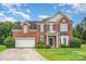 Charming two-story brick home with a well-manicured lawn and a two-car garage at 14911 Taggert Trail Dr, Charlotte, NC 28273