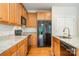 Bright kitchen with stainless steel appliances, wood cabinets, granite countertops, and hardwood flooring at 14911 Taggert Trail Dr, Charlotte, NC 28273
