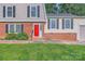 Inviting front facade with a vibrant red door, manicured lawn, and brick accents at 1506 Union New Hope Rd, Gastonia, NC 28056