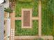 Aerial view showcasing a meticulously landscaped backyard with geometric garden beds and lush green lawns at 1579 Queens W Rd, Charlotte, NC 28207