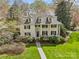 Beautiful two-story home featuring a manicured lawn, dormer windows and lush landscaping creating an inviting curb appeal at 1579 Queens W Rd, Charlotte, NC 28207