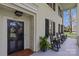 Inviting front porch featuring classic black rocking chairs, white columns and a charming entryway with sidelights at 1579 Queens W Rd, Charlotte, NC 28207