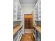 Elegant wine cellar with custom wooden racking and tiled floor, as seen from the pantry at 1579 Queens W Rd, Charlotte, NC 28207