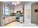 Functional kitchen with white cabinetry and vintage appliances overlooking the breakfast nook at 1658 Buckingham Ave, Gastonia, NC 28054