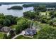 Stunning aerial view of lakefront estate with private docks, lush landscaping, and picturesque scenery at 176 Windwood Ln, Troutman, NC 28166