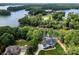 Aerial view of a luxury home with a private dock, surrounded by lush greenery and a lake at 176 Windwood Ln, Troutman, NC 28166
