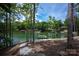Picturesque backyard leading to a lake with a dock and lush greenery at 176 Windwood Ln, Troutman, NC 28166