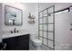 Tastefully designed bathroom featuring a glass enclosed shower, patterned floor, and modern vanity with black fixtures at 176 Windwood Ln, Troutman, NC 28166