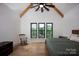 Spacious bedroom featuring a rustic rocking chair, hardwood floors, and three large windows with lake views at 176 Windwood Ln, Troutman, NC 28166
