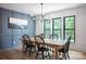 Dining room featuring a wooden table, black chairs, blue accent wall, and natural light at 176 Windwood Ln, Troutman, NC 28166