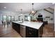 Open-concept kitchen and dining area with modern lighting, hardwood floors, and sliding door access at 176 Windwood Ln, Troutman, NC 28166