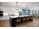 Kitchen island with bar stool seating, modern light fixtures, and hardwood floors at 176 Windwood Ln, Troutman, NC 28166