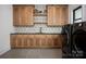 Well-appointed laundry room featuring custom wood cabinets, designer backsplash, and modern appliances at 176 Windwood Ln, Troutman, NC 28166