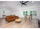 Bright living room with hardwood floors, modern lighting, and a comfortable leather couch at 176 Windwood Ln, Troutman, NC 28166