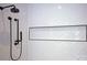 This shower features a sleek, built-in storage niche, contemporary fixtures, and modern white herringbone tiling at 176 Windwood Ln, Troutman, NC 28166