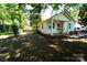 Backyard view of home with vinyl siding, a covered porch, and mature trees on a verdant lot at 201 W 19Th St, Kannapolis, NC 28081