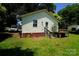 Shows a home's rear exterior with siding, a small porch and stairs with lawn and landscape features at 201 W 19Th St, Kannapolis, NC 28081