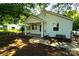 An eye-level view of a bungalow-style home featuring a covered front porch and well-kept lawn with mature shade trees at 201 W 19Th St, Kannapolis, NC 28081