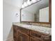 Bathroom vanity features wood cabinets, granite countertop, bronze fixtures, and large mirror at 20635 Queensdale Dr, Cornelius, NC 28031