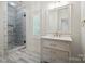 Bright bathroom featuring a glass shower, marble floors, and a vanity with marble counters at 20635 Queensdale Dr, Cornelius, NC 28031